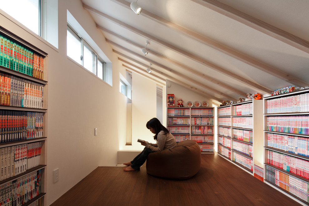 Photo of a mid-sized asian study room in Tokyo with white walls, bamboo floors, a built-in desk and brown floor.