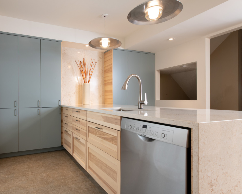 Photo of a modern u-shaped kitchen/diner in Ottawa with a submerged sink, shaker cabinets, light wood cabinets, engineered stone countertops, stainless steel appliances, vinyl flooring, a breakfast bar, multi-coloured floors and beige worktops.