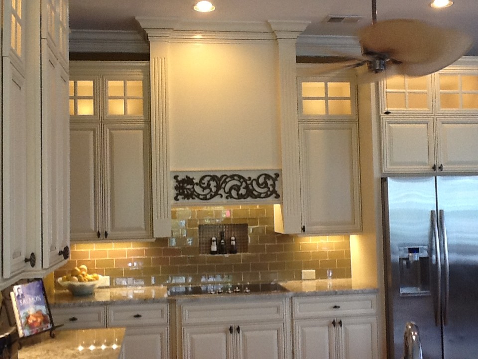 Example of a large island style u-shaped bamboo floor eat-in kitchen design in Charleston with a double-bowl sink, raised-panel cabinets, beige cabinets, granite countertops, brown backsplash, glass tile backsplash, stainless steel appliances and an island