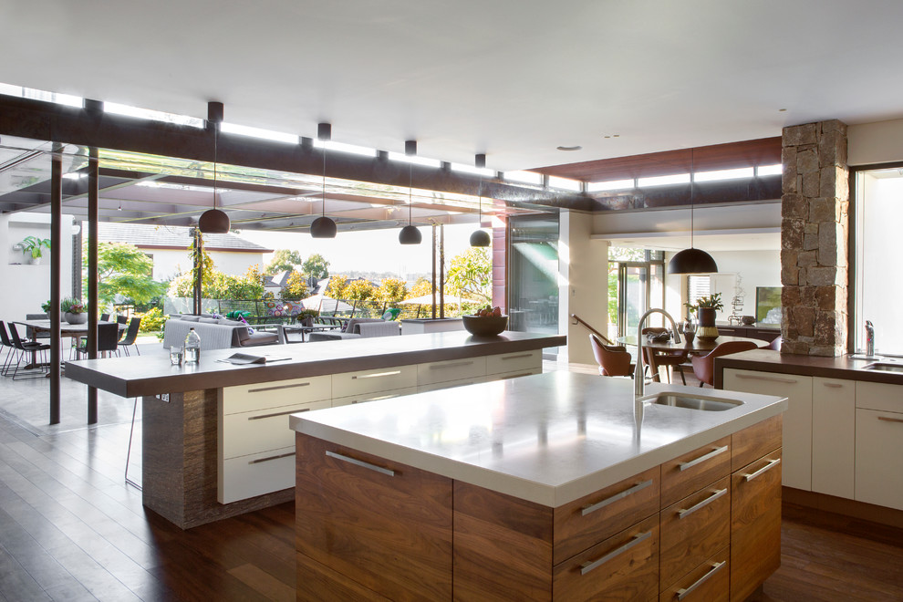 Inspiration for a large contemporary eat-in kitchen in Perth with an undermount sink, flat-panel cabinets, medium wood cabinets, granite benchtops, stone slab splashback, stainless steel appliances, medium hardwood floors and multiple islands.