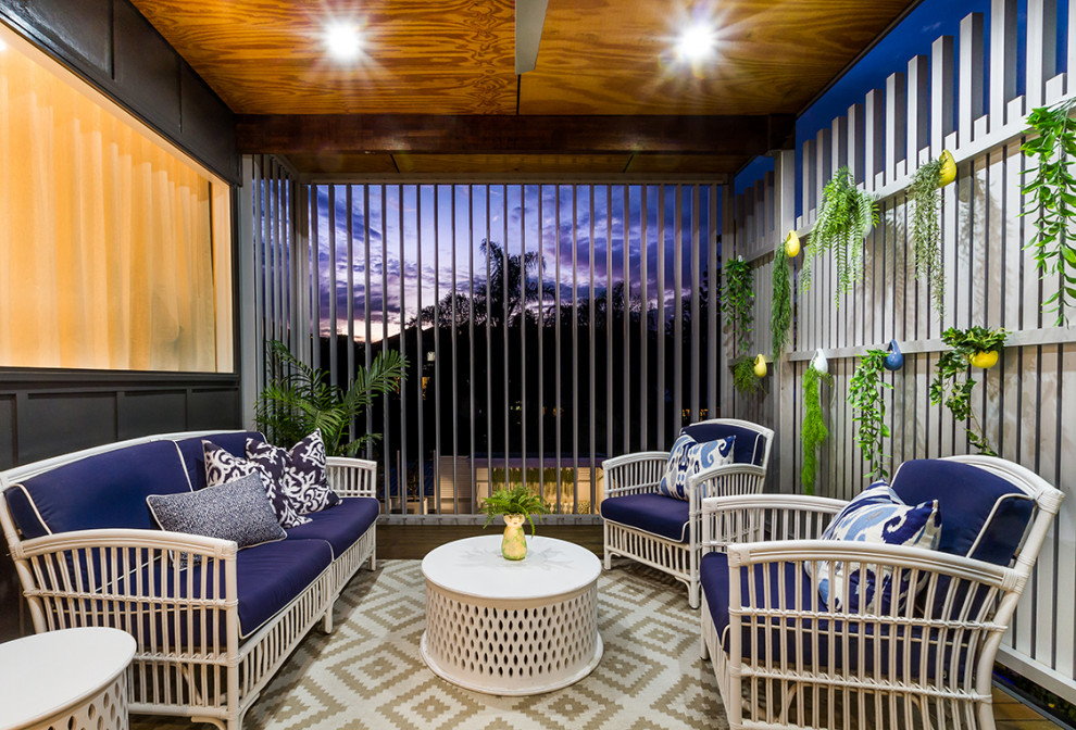 Photo of a mid-sized tropical balcony in Brisbane with a vertical garden, a roof extension and metal railing.