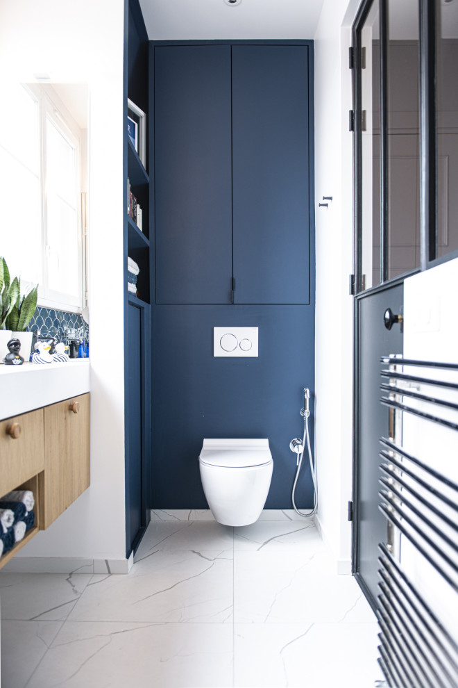 Пример оригинального дизайна: ванная комната в современном стиле с плоскими фасадами, синими фасадами, инсталляцией, синими стенами, душевой кабиной, белым полом и встроенной тумбой