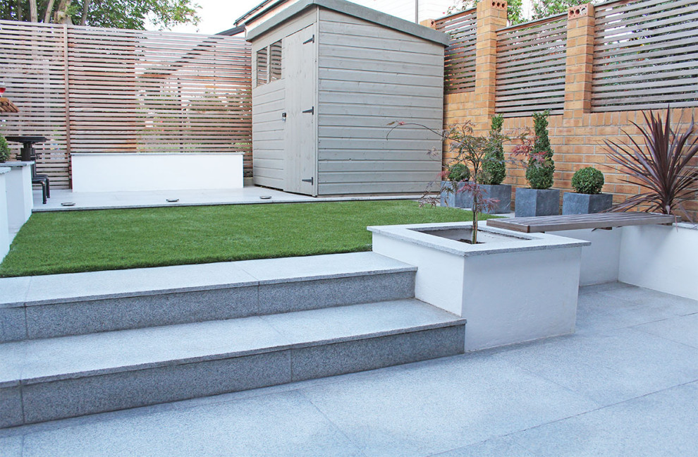 Diseño de patio actual de tamaño medio en patio trasero con adoquines de piedra natural