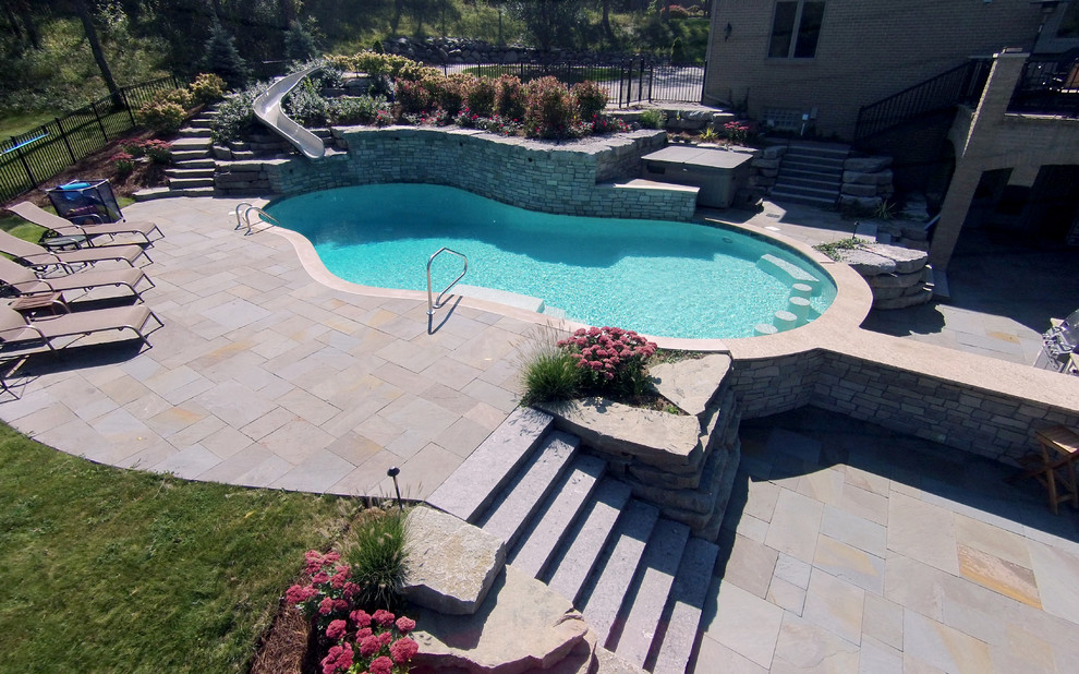 Example of a large transitional backyard stone and custom-shaped water slide design in Detroit