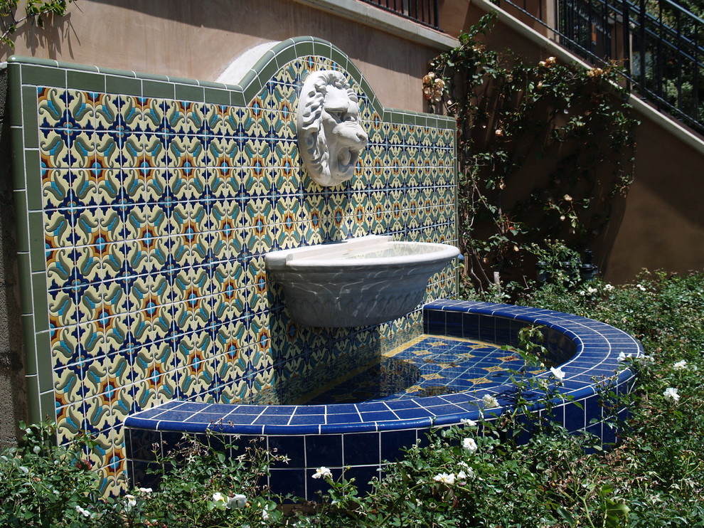 This is an example of a mid-sized mediterranean backyard full sun garden for summer in Los Angeles with concrete pavers.