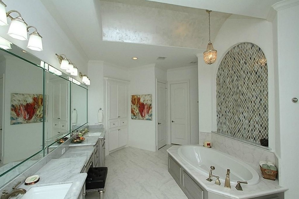 Photo of a large transitional master bathroom in Houston with an undermount sink, raised-panel cabinets, marble benchtops, a drop-in tub, multi-coloured tile, white walls, an alcove shower, a two-piece toilet, porcelain floors, grey cabinets and mosaic tile.