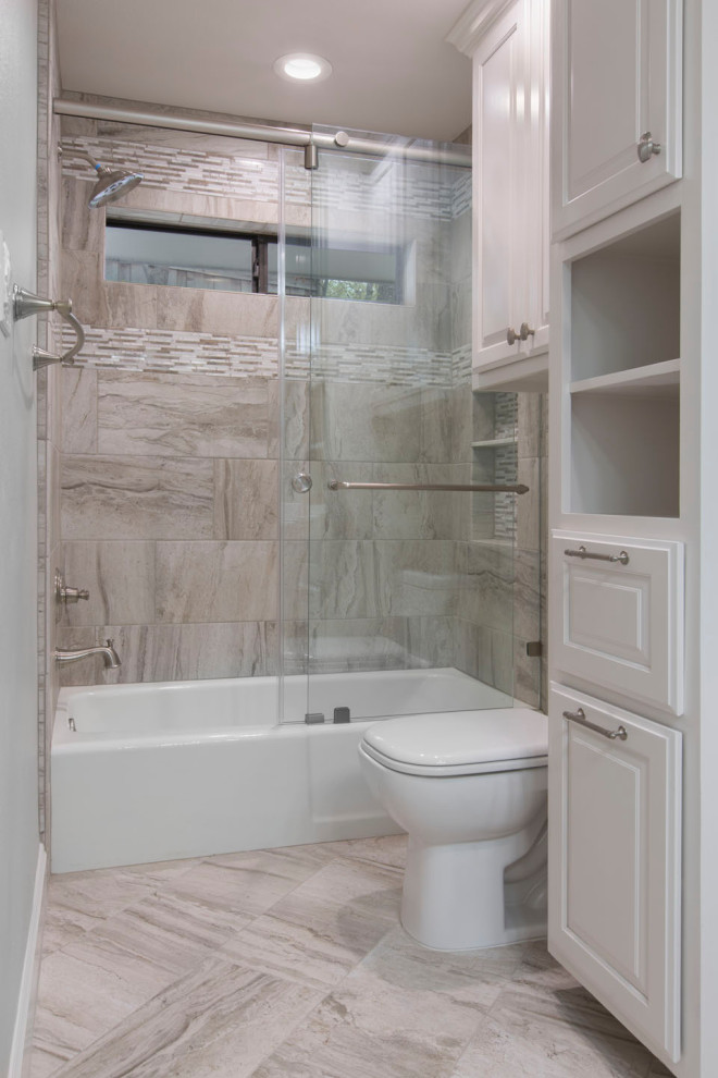 This is an example of a small transitional kids bathroom in Other with raised-panel cabinets, white cabinets, an alcove tub, a shower/bathtub combo, a two-piece toilet, beige tile, ceramic tile, beige walls, cement tiles, an undermount sink, granite benchtops, beige floor, a sliding shower screen and white benchtops.