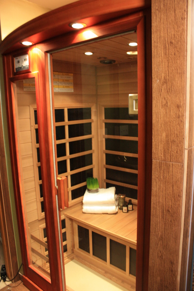 Mid-sized asian bathroom in Minneapolis with open cabinets, medium wood cabinets, a corner shower, a two-piece toilet, brown tile, pebble tile, green walls, porcelain floors, a vessel sink and wood benchtops.