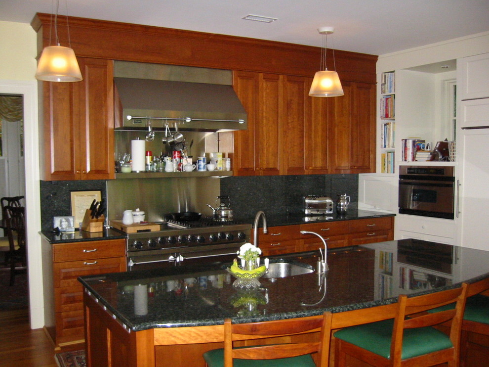 This is an example of a large traditional l-shaped eat-in kitchen in DC Metro with an undermount sink, raised-panel cabinets, medium wood cabinets, granite benchtops, stone slab splashback, stainless steel appliances, medium hardwood floors and with island.