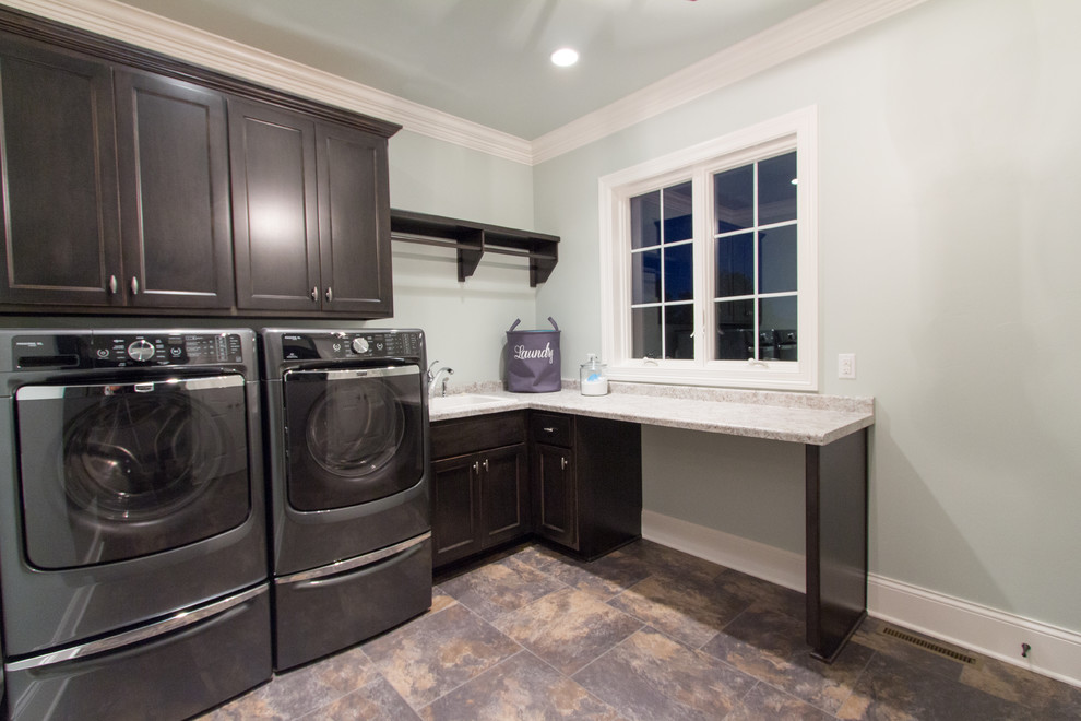 Inspiration for a transitional l-shaped laundry room in Milwaukee with shaker cabinets, dark wood cabinets and a side-by-side washer and dryer.