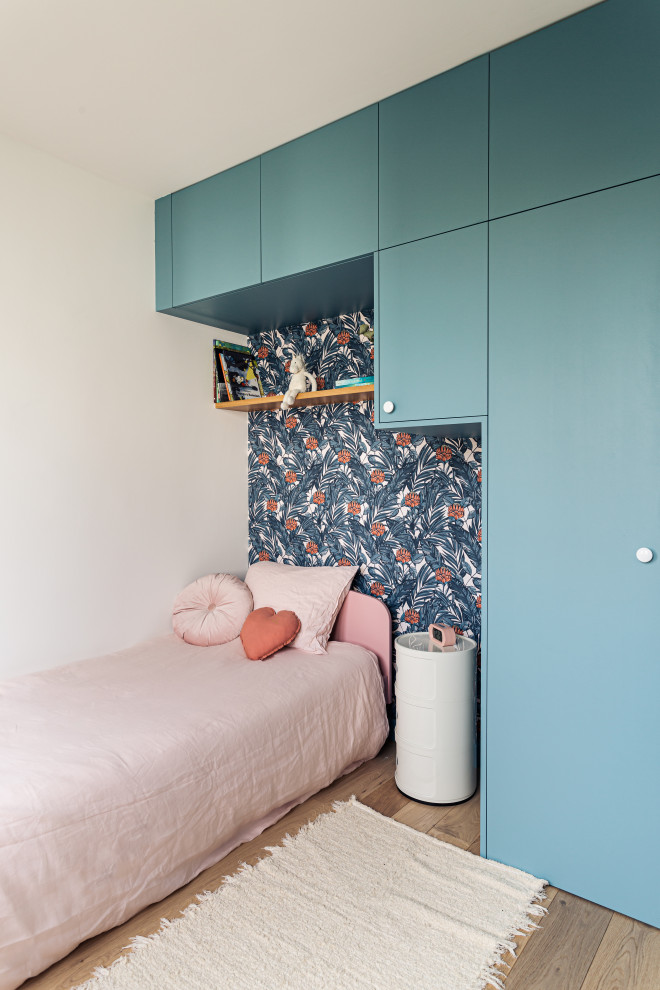 Idéer för att renovera ett mellanstort nordiskt könsneutralt tonårsrum kombinerat med sovrum, med blå väggar och ljust trägolv