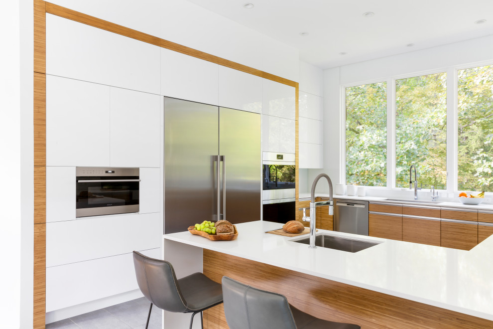 Inspiration for a large contemporary u-shaped porcelain tile and gray floor eat-in kitchen remodel in New York with flat-panel cabinets, white cabinets, quartz countertops, white backsplash, stone slab backsplash, stainless steel appliances, a peninsula and yellow countertops