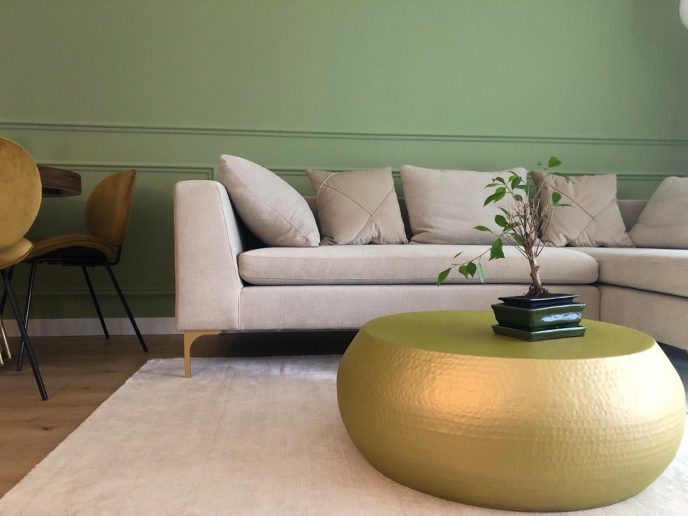Idee per un piccolo soggiorno aperto con pareti verdi, pavimento in laminato, TV a parete, boiserie e tappeto