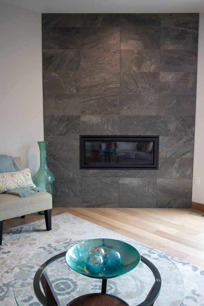 Inspiration pour un salon design avec un mur blanc, parquet clair, une cheminée d'angle, un manteau de cheminée en carrelage, un téléviseur fixé au mur et un sol marron.