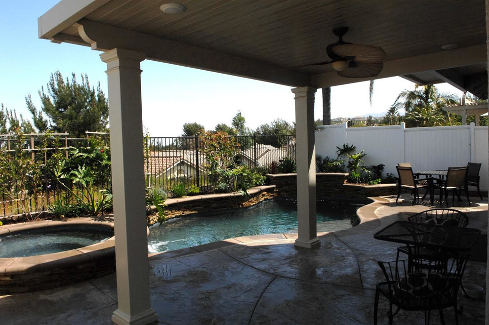 Mid-sized transitional backyard concrete paver and custom-shaped lap hot tub photo in Orange County