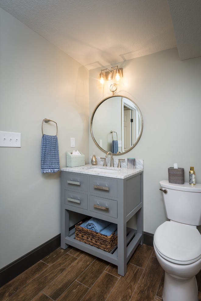 Inspiration for a small transitional 3/4 bathroom in Columbus with recessed-panel cabinets, grey cabinets, an alcove shower, grey walls, porcelain floors, an undermount sink, marble benchtops, brown floor, a sliding shower screen and white benchtops.