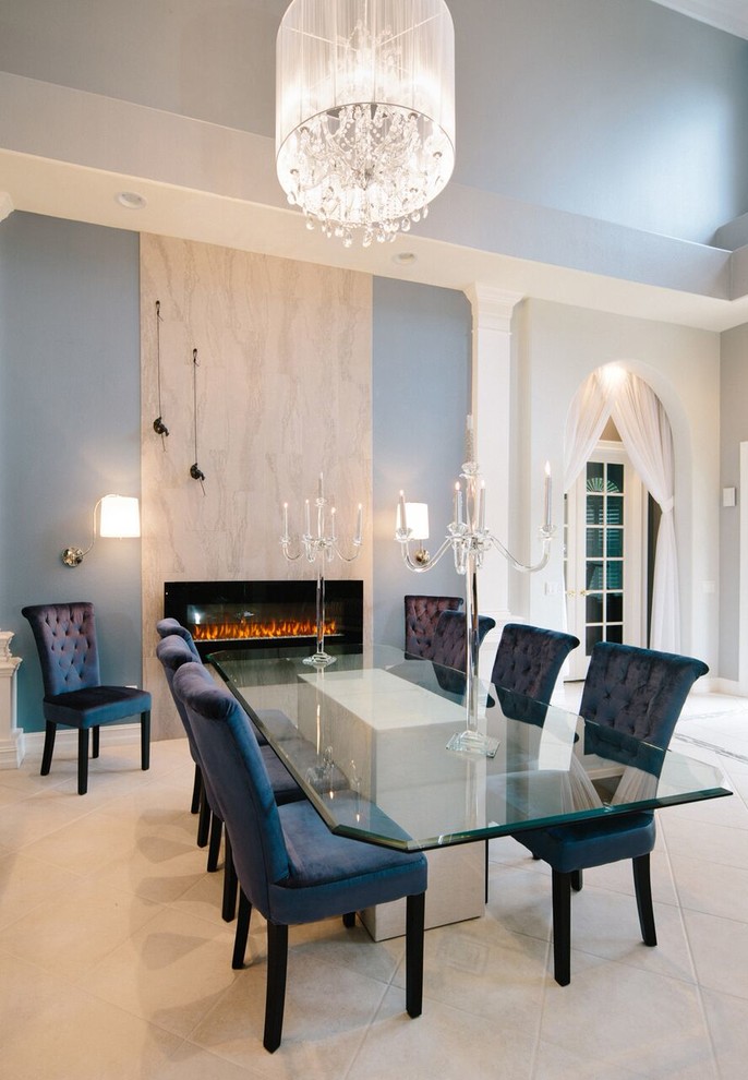 Example of a large transitional travertine floor and beige floor enclosed dining room design in Miami with white walls, a ribbon fireplace and a stone fireplace