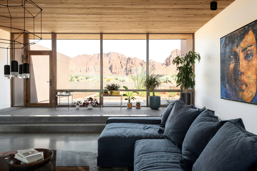 Offenes Wohnzimmer mit weißer Wandfarbe, Betonboden, grauem Boden und Holzdecke in Salt Lake City
