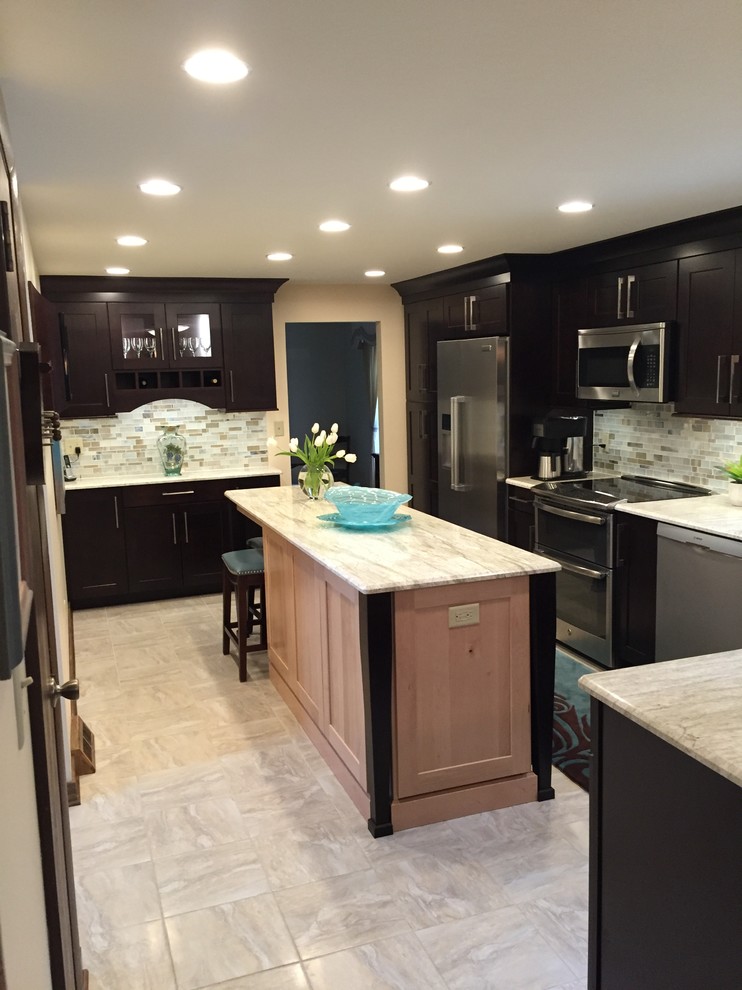 Example of a transitional ceramic tile kitchen design with dark wood cabinets, multicolored backsplash, mosaic tile backsplash, stainless steel appliances and an island