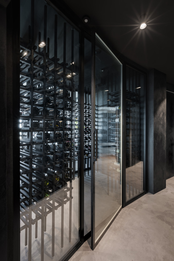 Mid-sized industrial wine cellar in Los Angeles with concrete floors, storage racks and grey floor.