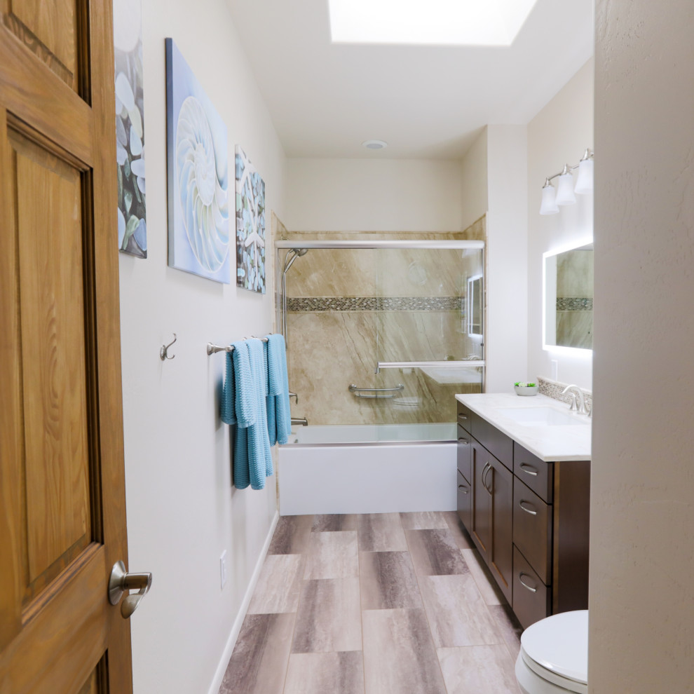 Exempel på ett mellanstort klassiskt vit vitt badrum med dusch, med skåp i shakerstil, skåp i mörkt trä, ett badkar i en alkov, en dusch/badkar-kombination, en toalettstol med hel cisternkåpa, flerfärgad kakel, stenhäll, vita väggar, vinylgolv, bänkskiva i akrylsten, flerfärgat golv, dusch med skjutdörr och ett undermonterad handfat
