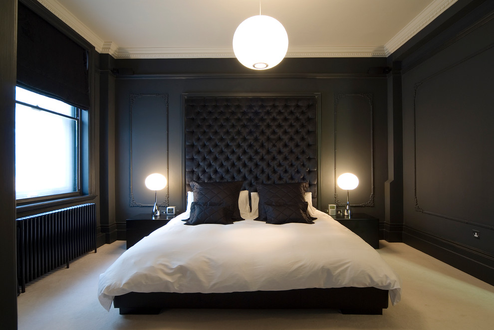 This is an example of a mid-sized modern master bedroom in London with black walls, carpet, a corner fireplace and a stone fireplace surround.