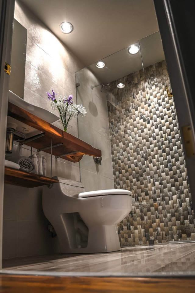 This is an example of a small contemporary 3/4 bathroom in Austin with a vessel sink, recessed-panel cabinets, wood benchtops, a curbless shower, a one-piece toilet, white tile, porcelain tile, white walls and marble floors.