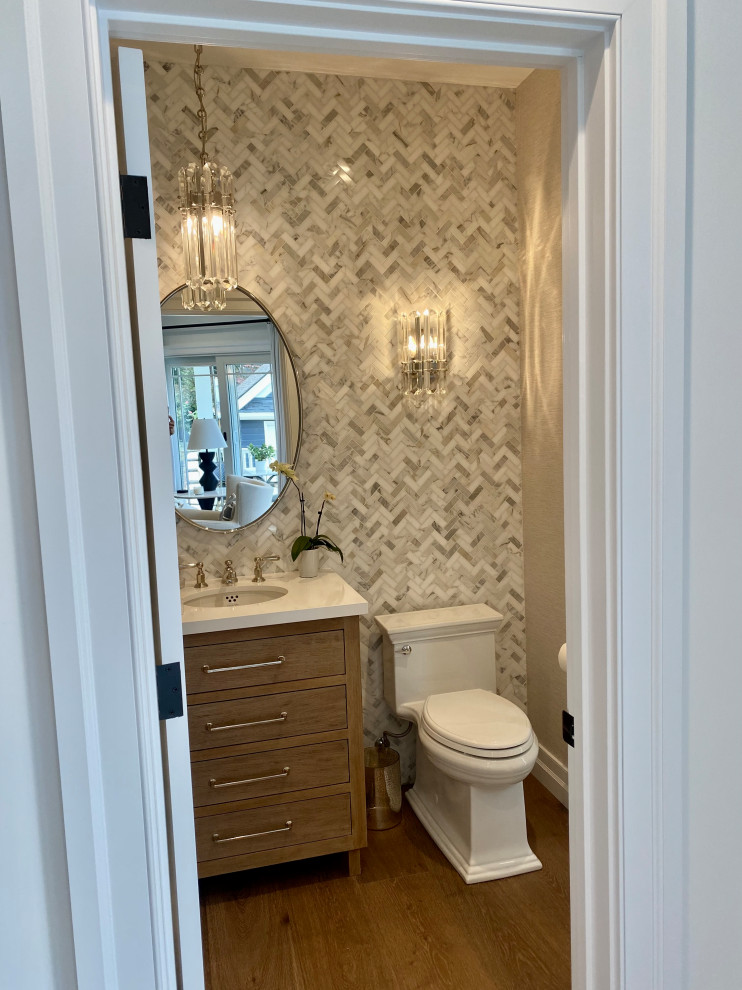 Medium sized classic bathroom in Other with beaded cabinets, light wood cabinets, a one-piece toilet, multi-coloured tiles, stone tiles, light hardwood flooring, a submerged sink, engineered stone worktops, a hinged door, white worktops, a single sink, a freestanding vanity unit and wallpapered walls.
