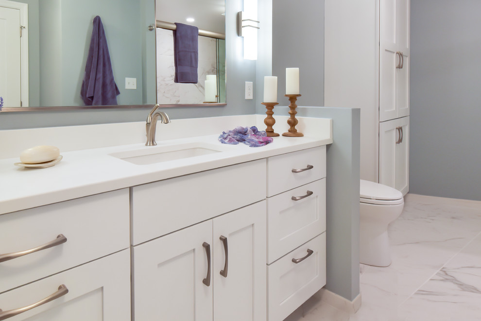 Mid-sized transitional master bathroom in DC Metro with shaker cabinets, white cabinets, an alcove shower, a two-piece toilet, blue walls, porcelain floors, an undermount sink, engineered quartz benchtops, white floor and white benchtops.