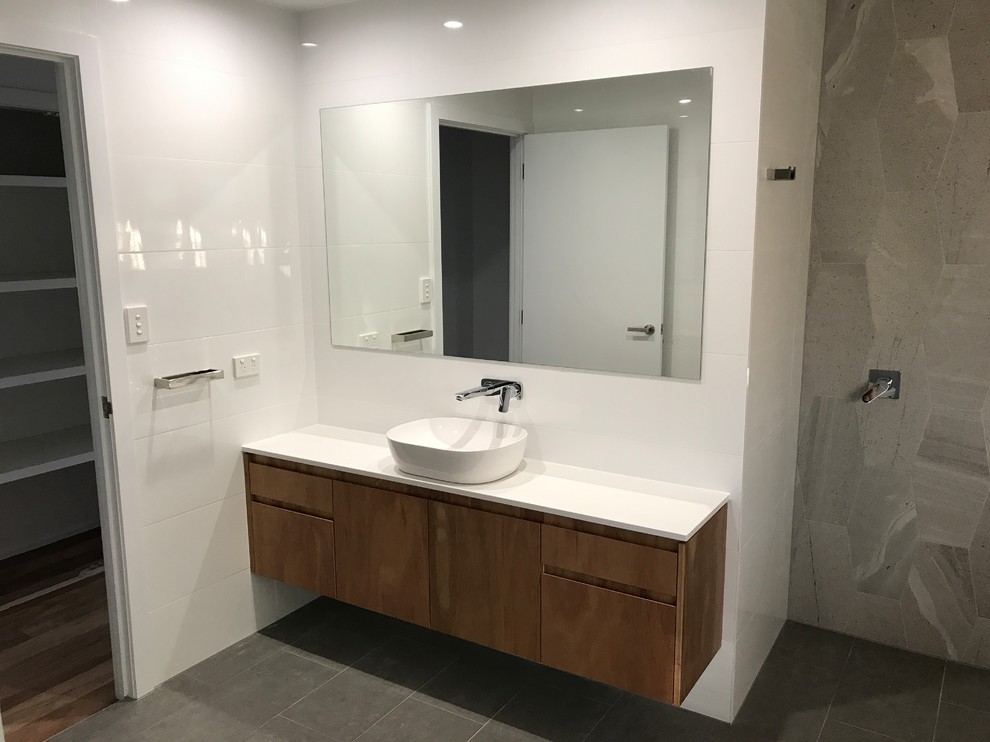 Mid-sized contemporary master bathroom in Other with open cabinets, a freestanding tub, cement tile, beige walls, cement tiles, a vessel sink and grey floor.