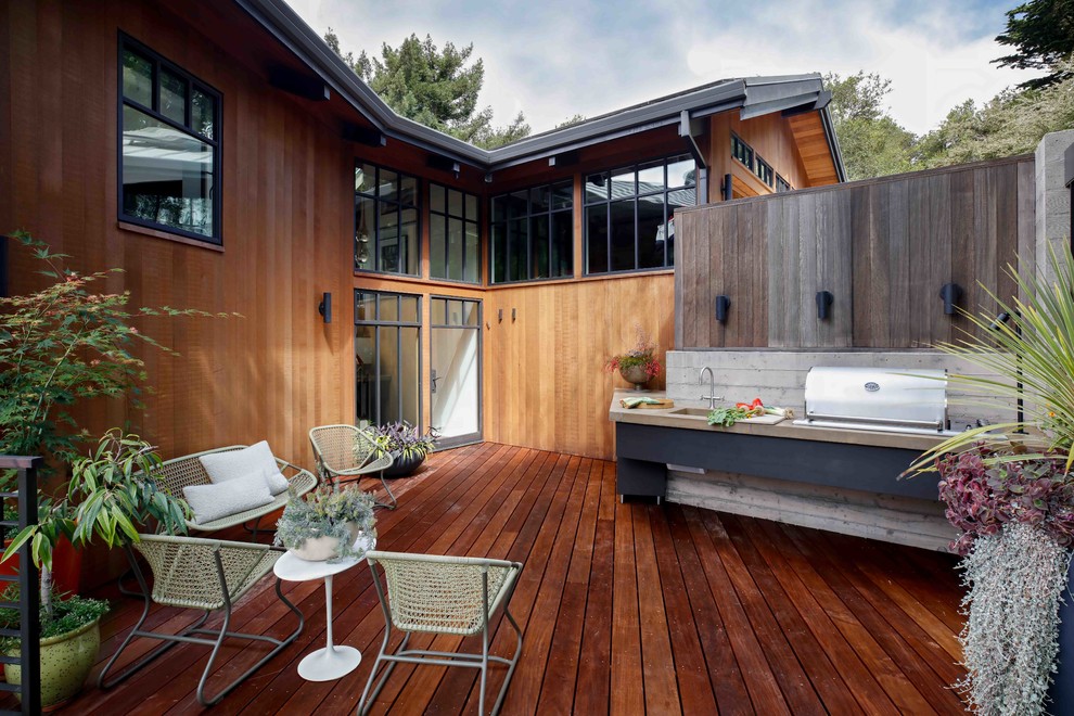 This is an example of a transitional backyard deck in San Francisco with an outdoor kitchen and no cover.