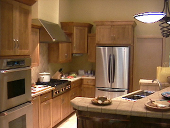 Mid-sized transitional enclosed kitchen photo in Milwaukee with a drop-in sink, recessed-panel cabinets, light wood cabinets, granite countertops, beige backsplash, ceramic backsplash and stainless steel appliances