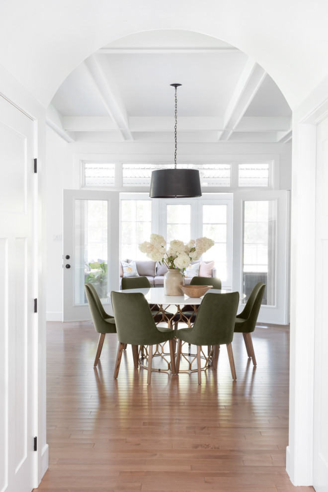 This is an example of a large contemporary dining room in Montreal with white walls, medium hardwood floors, no fireplace, brown floor, coffered and panelled walls.