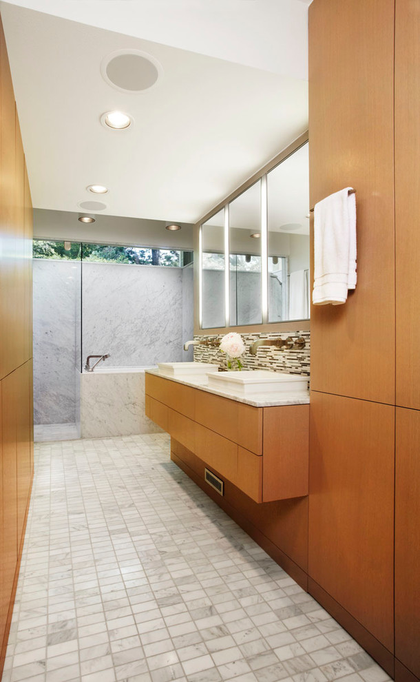 Photo of a midcentury bathroom in Minneapolis with marble benchtops.