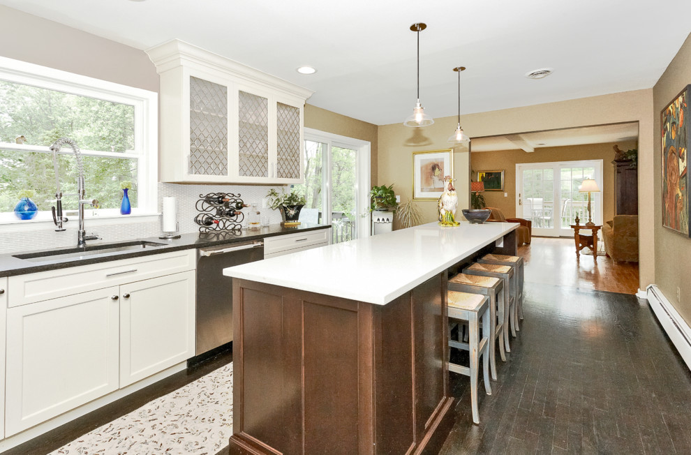 Inspiration for a mid-sized transitional l-shaped dark wood floor and brown floor eat-in kitchen remodel with an undermount sink, shaker cabinets, white cabinets, quartz countertops, white backsplash, glass sheet backsplash, stainless steel appliances and an island