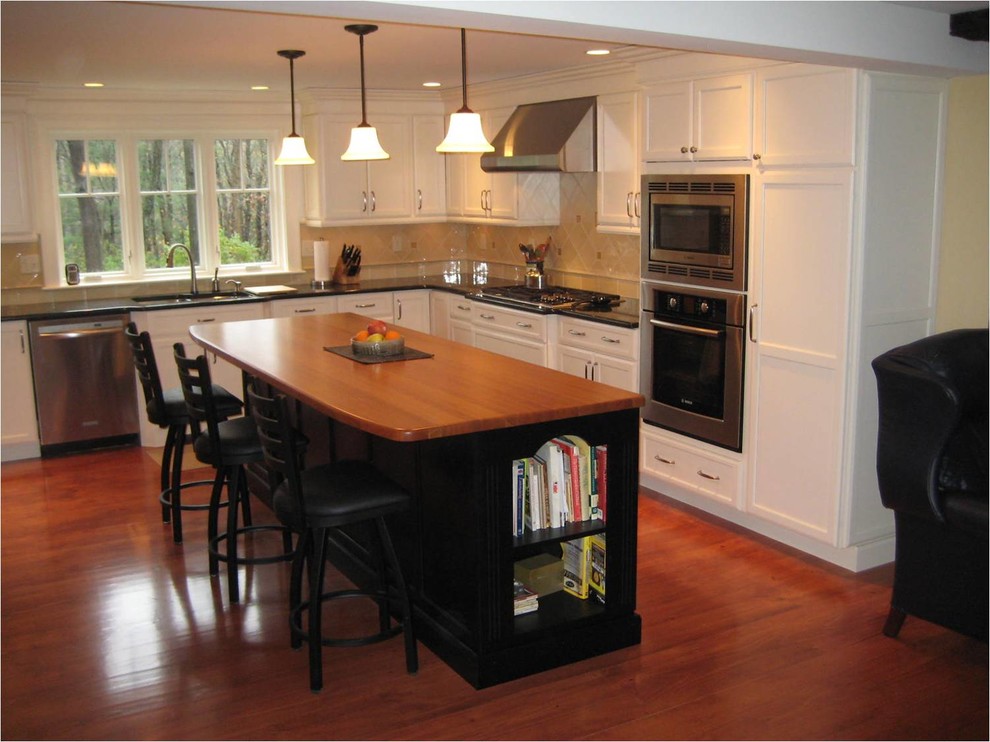 Design ideas for a large traditional l-shaped eat-in kitchen in Boston with an undermount sink, recessed-panel cabinets, white cabinets, granite benchtops, beige splashback, porcelain splashback, stainless steel appliances and medium hardwood floors.