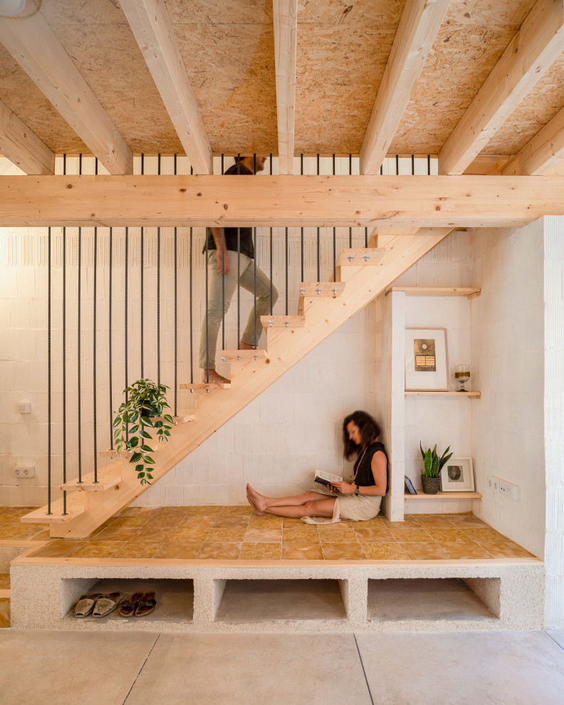 Imagen de escalera recta mediterránea pequeña sin contrahuella con escalones de madera, barandilla de metal y ladrillo