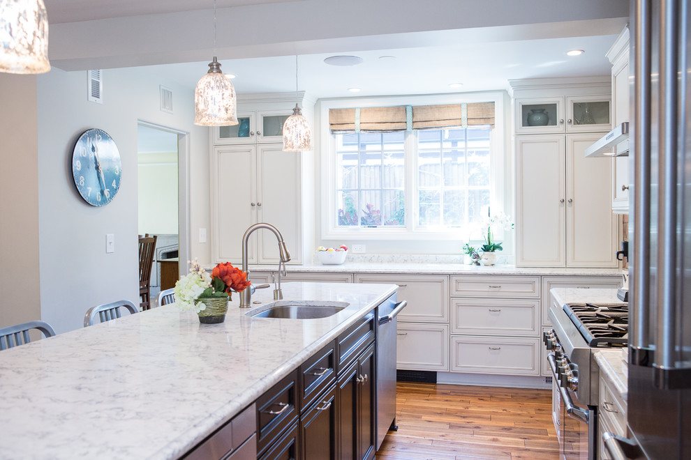 Eat-in kitchen - large transitional medium tone wood floor eat-in kitchen idea with an undermount sink, recessed-panel cabinets, black cabinets, quartz countertops, brick backsplash, stainless steel appliances and an island