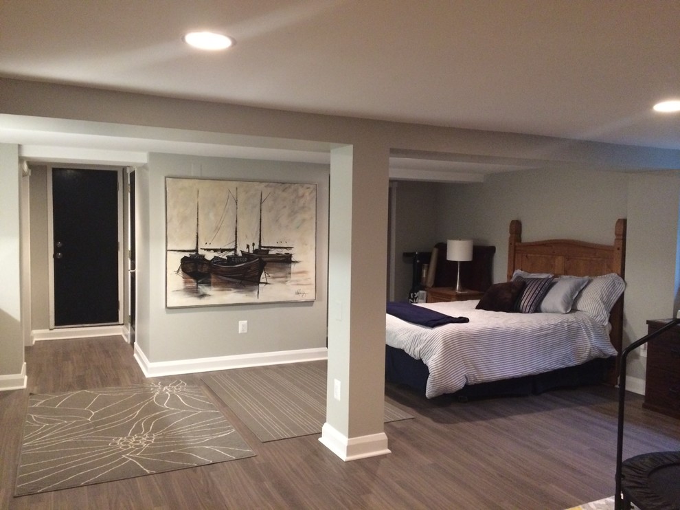 Inspiration for a mid-sized transitional underground laminate floor and brown floor basement remodel in Baltimore with gray walls