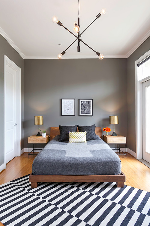 minimalist bedroom with grey bedding and accent wall and sputnik ceiling light 