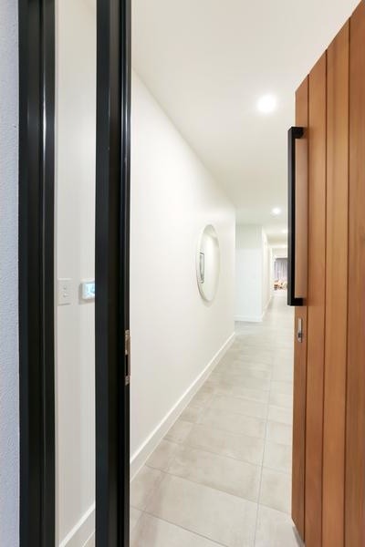 This is an example of a large contemporary hallway in Adelaide with white walls, porcelain floors and white floor.