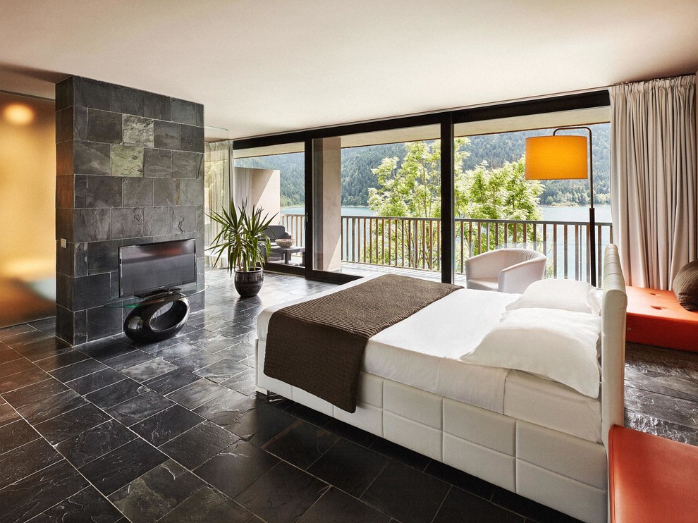 This is an example of a large contemporary master bedroom in Other with black walls and black floor.