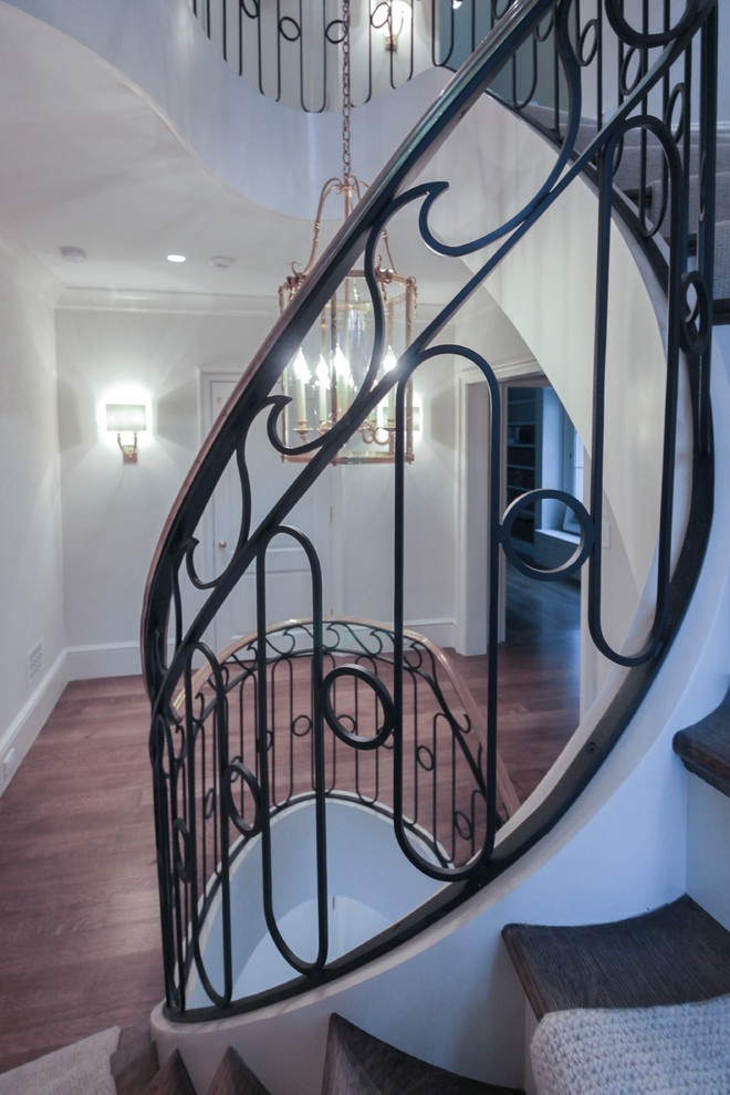 Staircase - large transitional wooden curved metal railing staircase idea in DC Metro with wooden risers