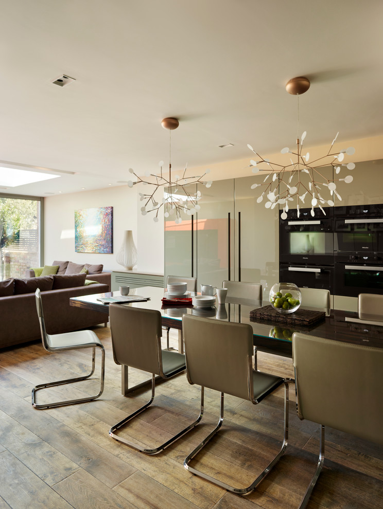 Design ideas for a contemporary open plan dining in London with medium hardwood floors.