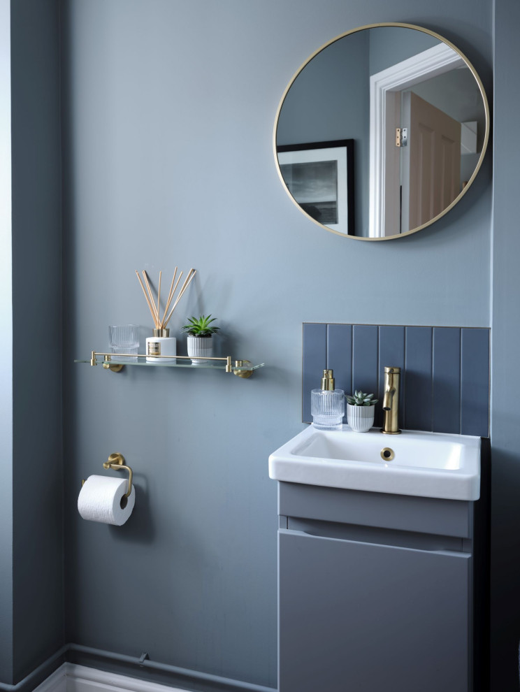 Inspiration for a small modern bathroom in Gloucestershire with flat-panel cabinets, grey cabinets, gray tile, porcelain tile, grey walls, vinyl floors, a wall-mount sink, tile benchtops, brown floor, grey benchtops, a single vanity and a built-in vanity.