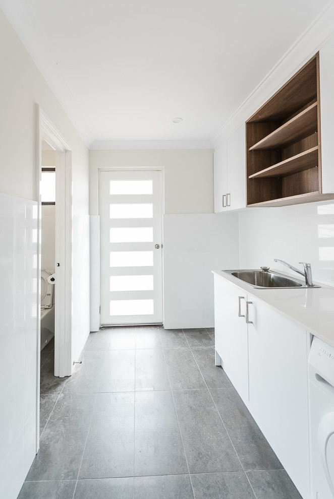 Contemporary single-wall dedicated laundry room in Perth with a drop-in sink, flat-panel cabinets, medium wood cabinets, quartz benchtops, white walls, porcelain floors and a side-by-side washer and dryer.