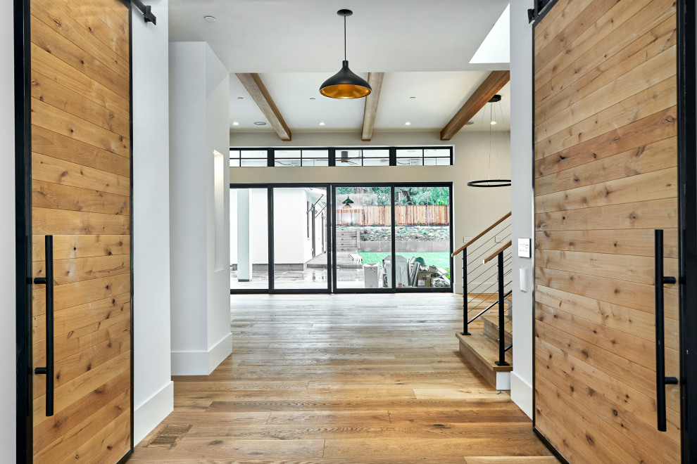 Photo of a large modern hallway in San Francisco with grey walls, medium hardwood floors and brown floor.