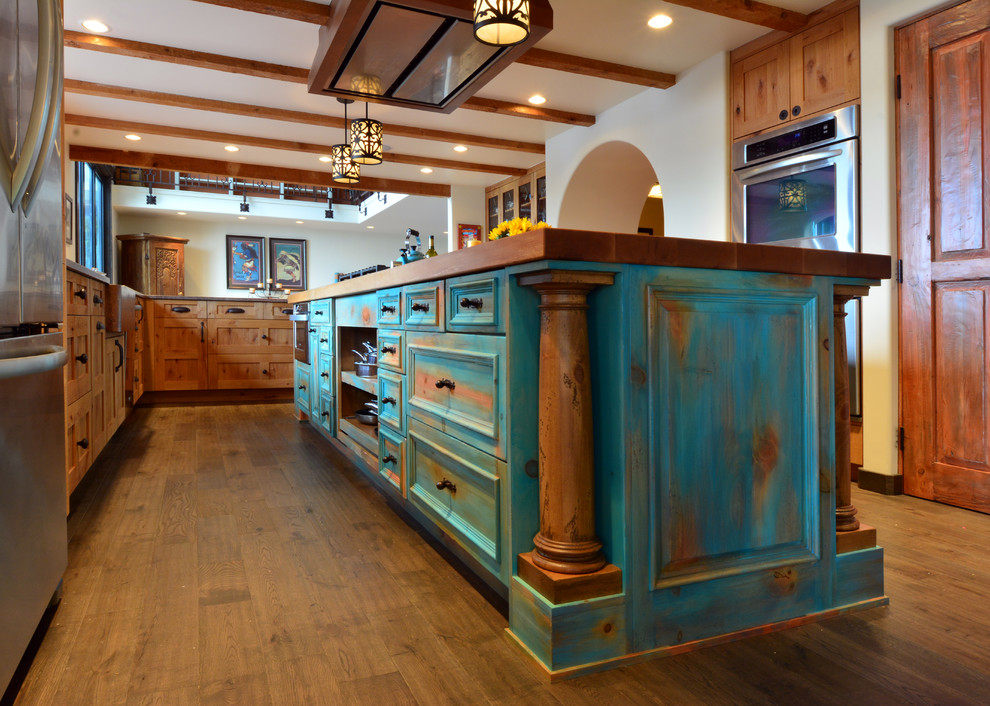 Inspiration for a large l-shaped open plan kitchen in Seattle with a farmhouse sink, recessed-panel cabinets, turquoise cabinets, wood benchtops, multi-coloured splashback, ceramic splashback, stainless steel appliances, medium hardwood floors, with island and brown floor.
