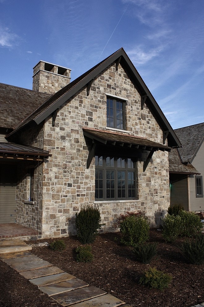 Design ideas for a large country two-storey brown exterior in Other with stone veneer.