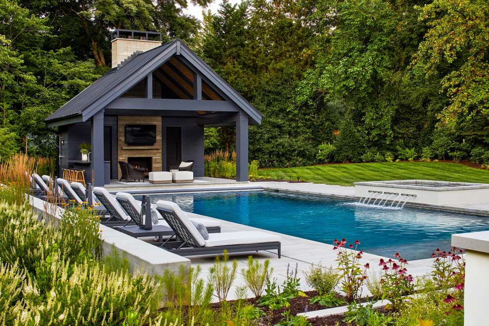 Esempio di una grande piscina chic rettangolare dietro casa con una dépendance a bordo piscina e pavimentazioni in cemento